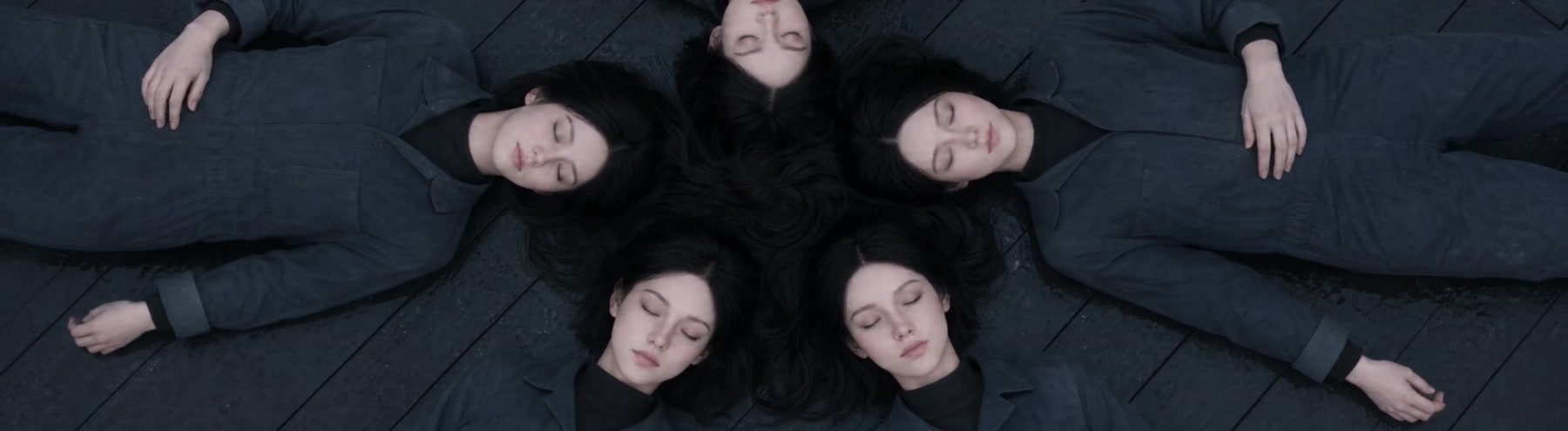 Five figures lying in a circle on the deck